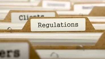Ordner mit der Beschriftung 'Regulations' in einem Aktenschrank.