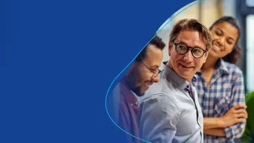 Vielfältige Gruppe von professionell gekleideten Erwachsenen, die in einer Büroumgebung lächeln.